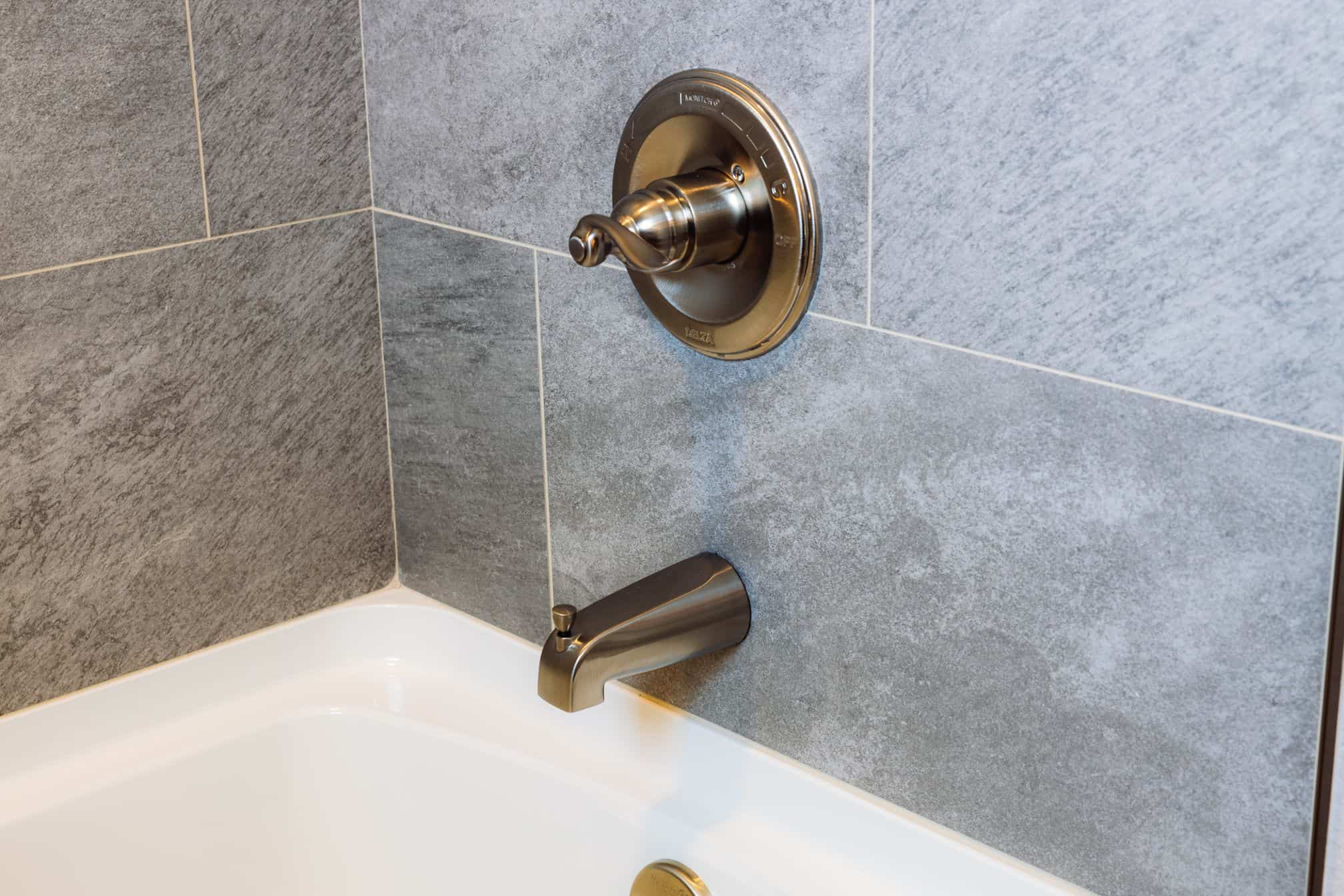grey tile and bronze faucet